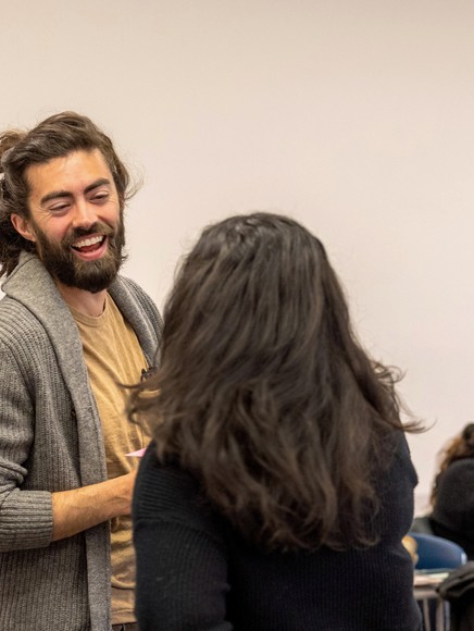 Student facing camera laughing with another student