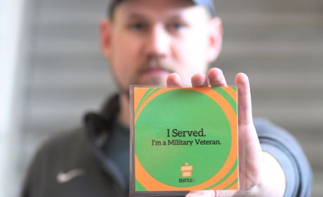 Student holding card reading: I Served. I am A Military Veteran.