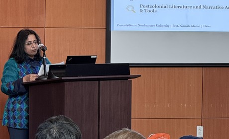 Professor Menon speaking at podium