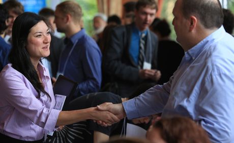 Student and recruiter shaking hands at a career fair event.