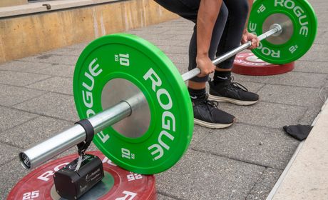 Closeup shot of the shoes and weights of someone about to lift weights