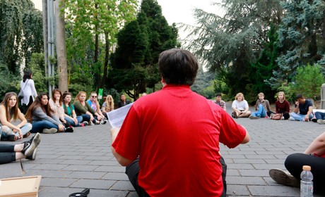 Students sit in a circle and listen to leader