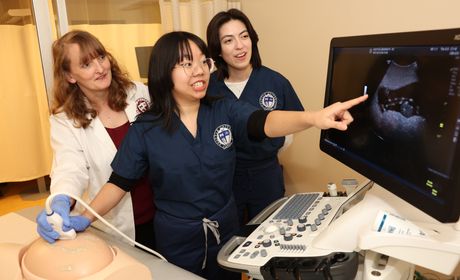 Two Ultrasound students work on their imaging skills with a faculty member