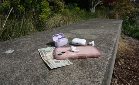 Cell phone, $20 bill, and two sets of headphones left at a seating area outdoors.