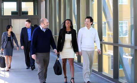 Three students from the EMBA class walking on the skybridge