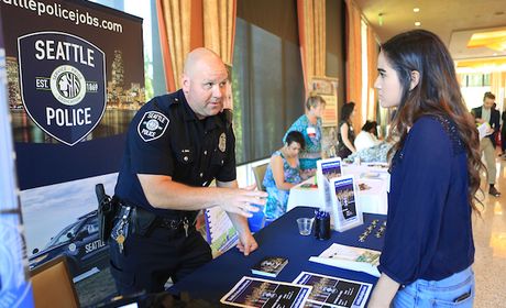 Police officer talking to student at a job and internship fair