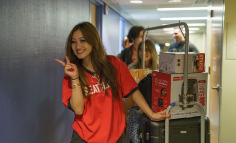 Student Moving into a Dorm Room Flashes Peace Sign