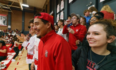 Students smiling and cheering at MBB game