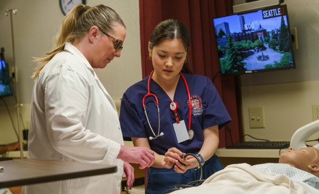 Student and Faculty look at blood pressure dial