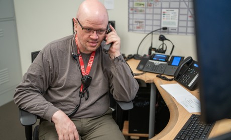 DPS dispatcher on the phone at desk in communications center.