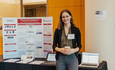 female student standing with project poster at Projects Day