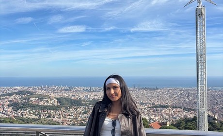 Woman standing at a scenic overlook, overseeing a large cityscape
