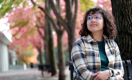 A student sitting in front of trees