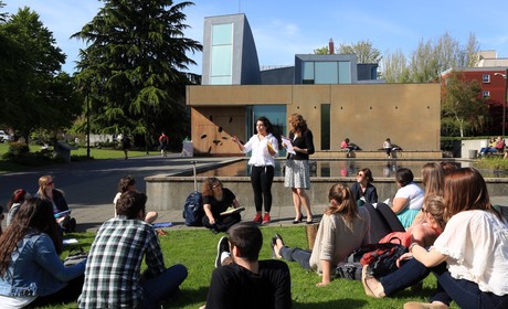 A group of people sitting on grass.