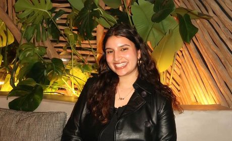A woman sitting in front of a plant