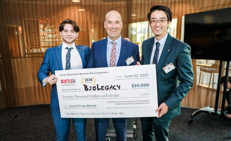Three individuals holding a check that shows BioLegacy
