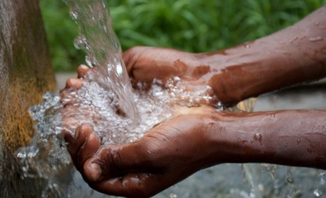 hands under a water spigot