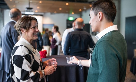 Two individuals engaging in a conversation at a networking event.