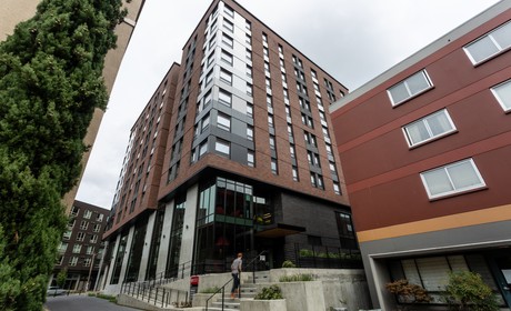 A large building with a sidewalk in front of it.