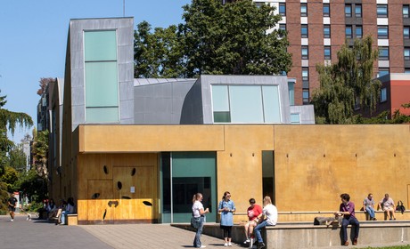 A yellow building with people standing around it.