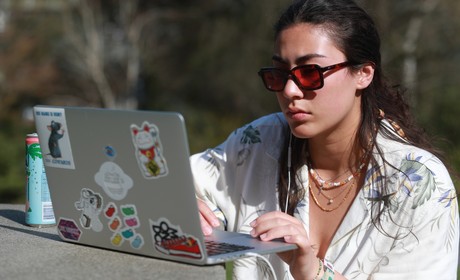 A woman using a laptop in a park.