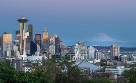 Seattle skyline with space needle and mt. rainier in the background at dusk.