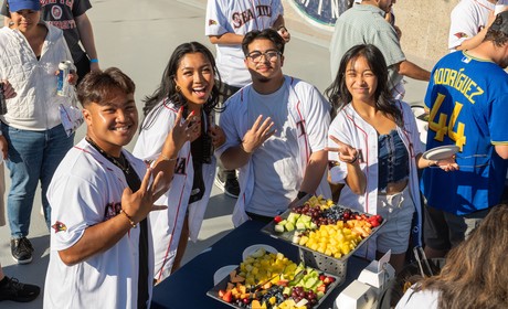 Students posing in front of buffet at mariners night