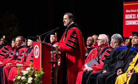 President Peñalver speaking at podium amongst university provosts