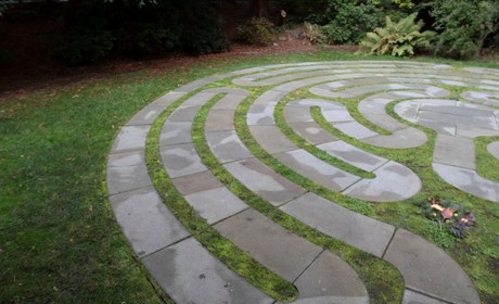 A circular stone labyrinth in a garden.
