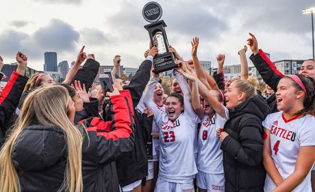 Women's Soccer team holding up a trophy after winning the WAC championship