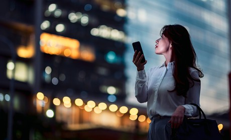 A woman outside in a metropolitan area using a cellphone