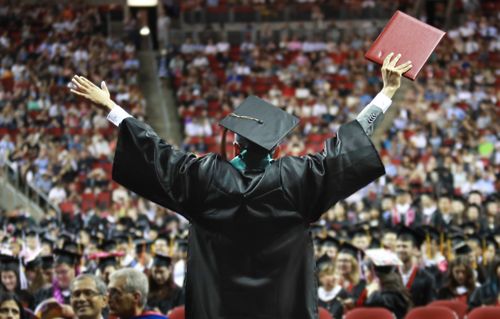 Graduate celebrating holding up diploma