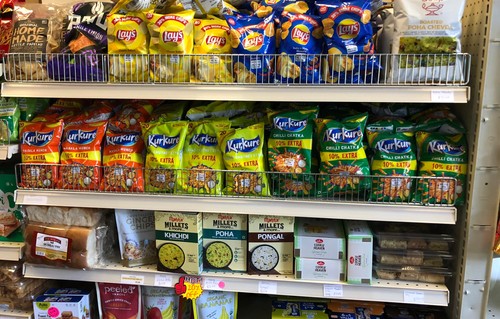 Indian food products stuffed into multiple levels of supermarket shelves