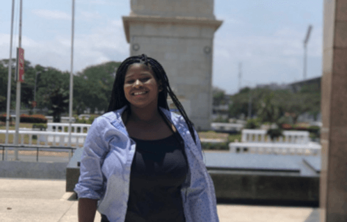 Smiling woman standing in front of Accra National Monument