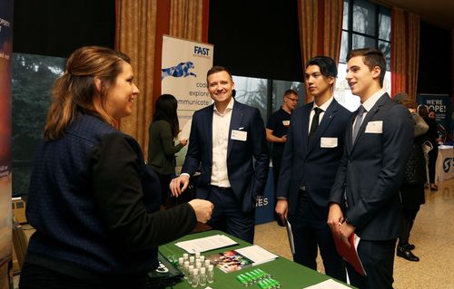 Professionals engaging in conversation at a networking event.