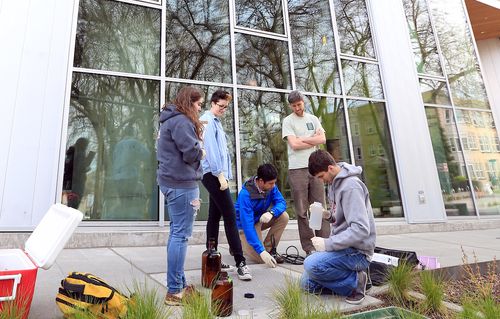A groups of five students working outside of Bullitt Center.