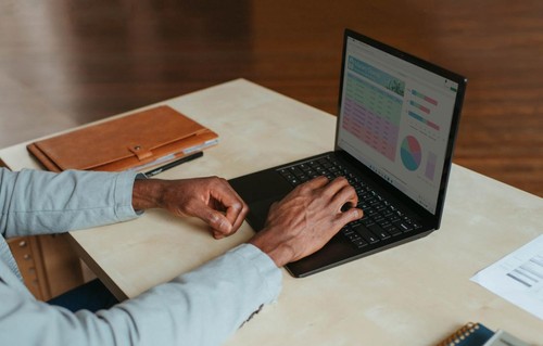 Hands typing on a laptop