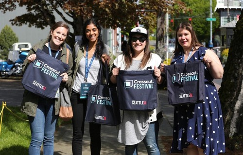 a group of women holding crosscut and �鶹��ýӳ�� drawstring bags
