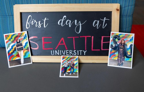 a picture of students in front of a first day of class sign