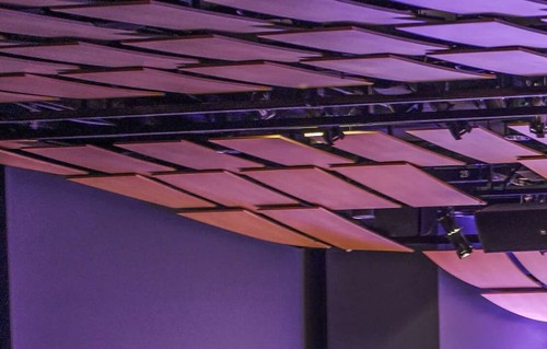 An auditorium with a full audience and a speaker