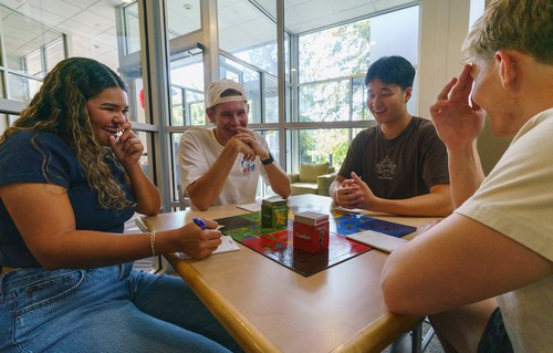 4 students playing a board game