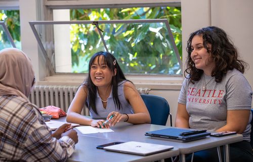 Seattle University students engaged in discussion with each other during class.