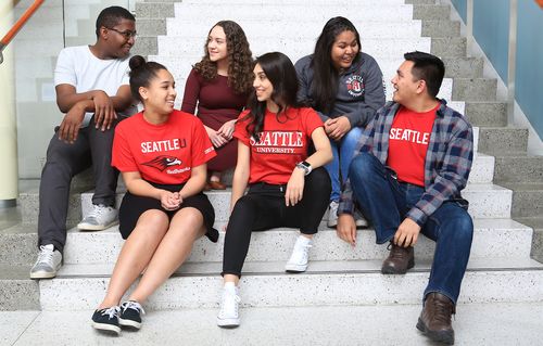 Five students seated on the steps.