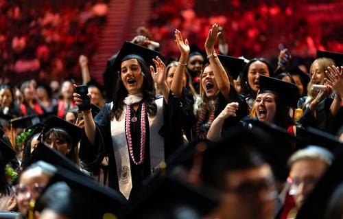 Group of BSN graduates in cap and gown celebrating at commencement.