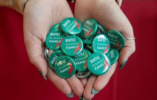 A woman's hands holding buttons with text 