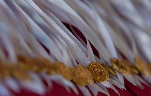 A row of College of Nursing pins on white ribbons