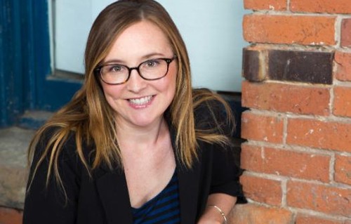 a profile photo of Carey Evenson standing next to a brick wall