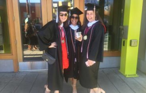 A photo of three women wearing graduation robes