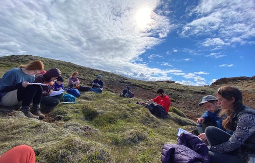 Students at a lecture on a bed of moss