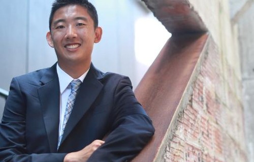 A profile photo of Alan Yu standing on a brick staircase
